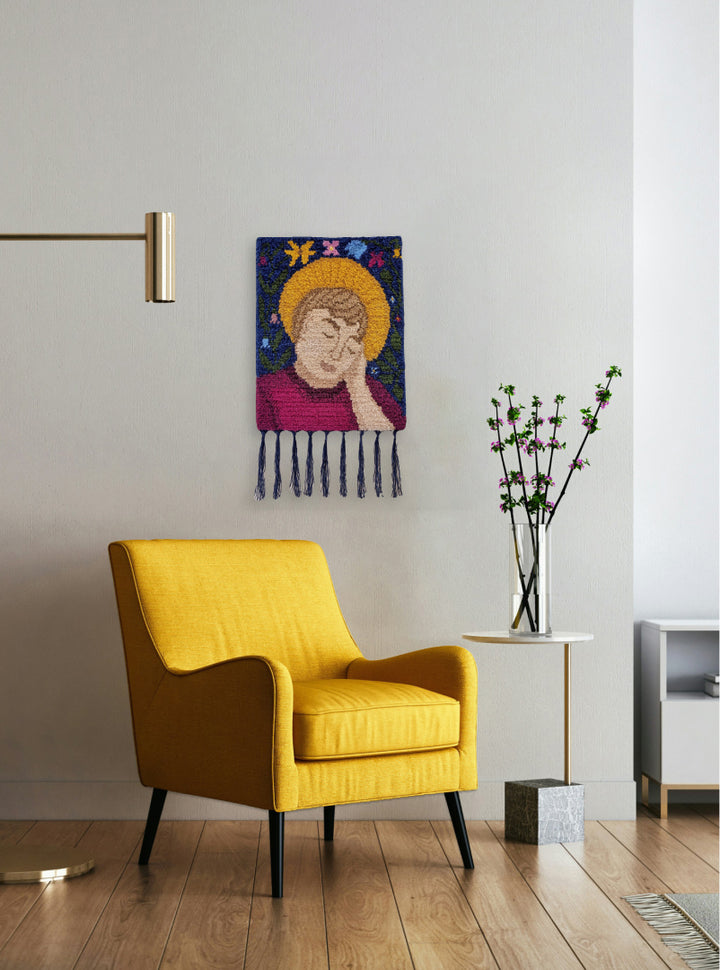 Self-portrait artwork on wall next to chair